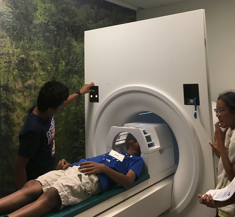 UCI Brain Camp Student Selected to Present Research at International Conference - image of Siddhant Karmali in mock MRI scanner at Brain Camp