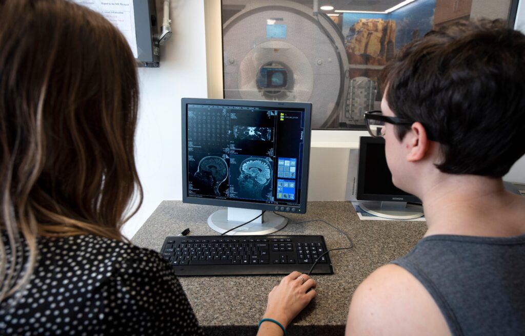 Students examining human brain research on computer