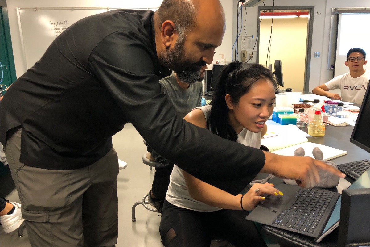 CNLM Earns University Designation as an Organized Research Unit - image of UCI Neuroscience faculty member, Dr. Sunil Gandhi assisting student in research