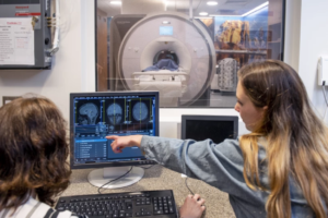 UCI poised to advance depression research following $55-million gift to establish center, featuring CNLM Fellows, Tallie Z. Baram and Michael A. Yassa - students examining human brain on computer screen in neuroscience lab