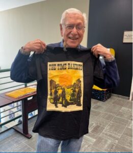 Dr. James McGaugh at the 2024 CNLM Spring Meeting holding the conference t-shirt.