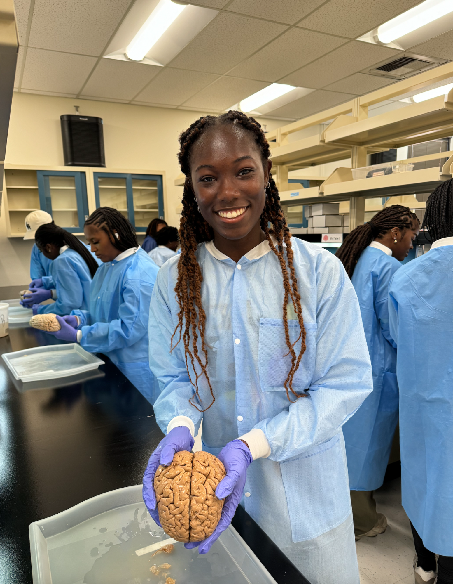 Déja Lee holds a preserved human brain during the CNLM Irvine Summer Institute in Neuroscience