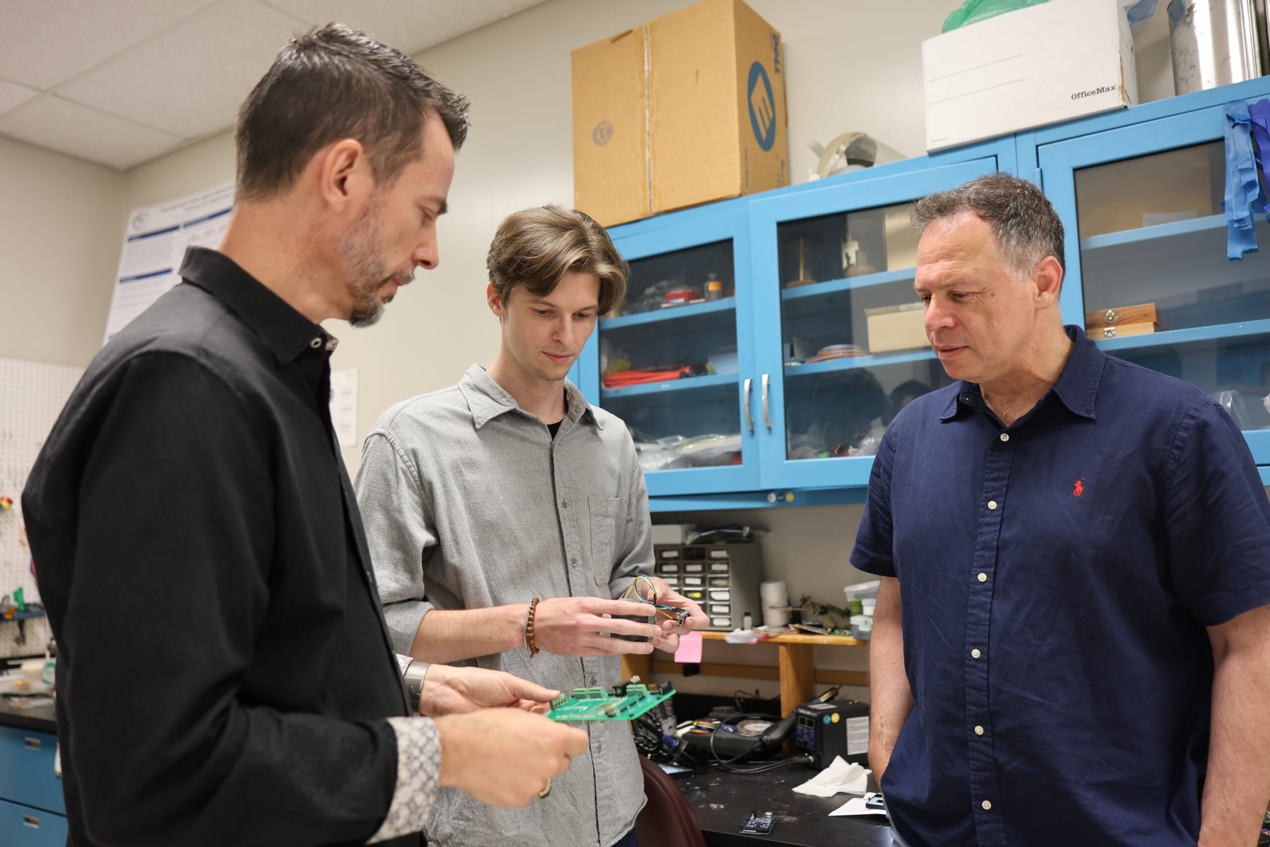Dr. Norbert Fortin, Dr. Keiland Cooper, and Dr. Babak Shahbaba examine a circuit board developed by Dr. Cooper to capture real-time, high-resolution behavioral data that will be integrated with brain activity data recordings. Photo: Carline Dong.