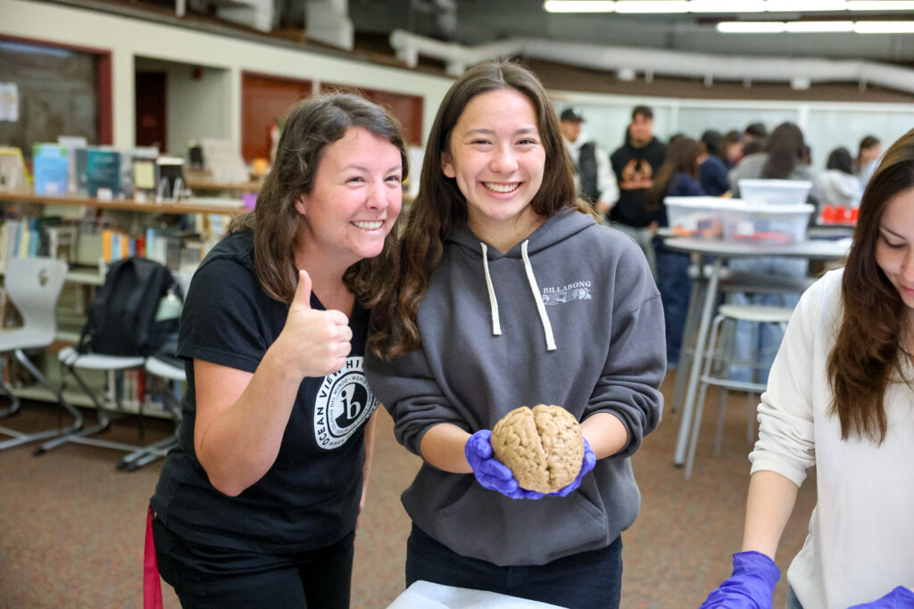 High school student and teacher holding a brain